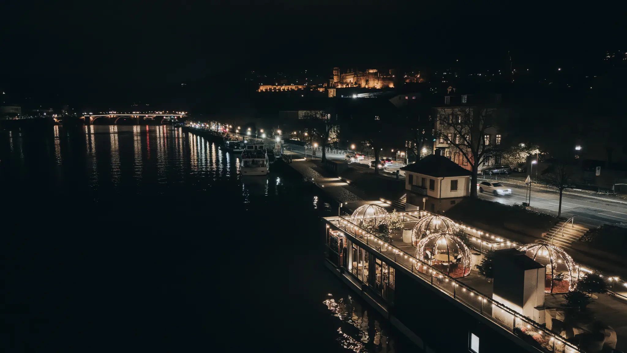Pier IV Deck bei Nacht mit leuchtenden Iglus, Schloss im Hintergrund