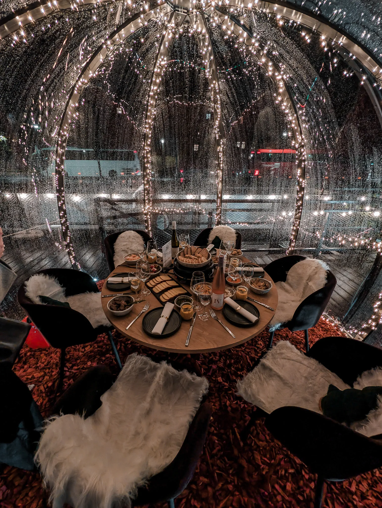 Iglu von innen mit Lichterketten, Fellen und gedecktem Tisch