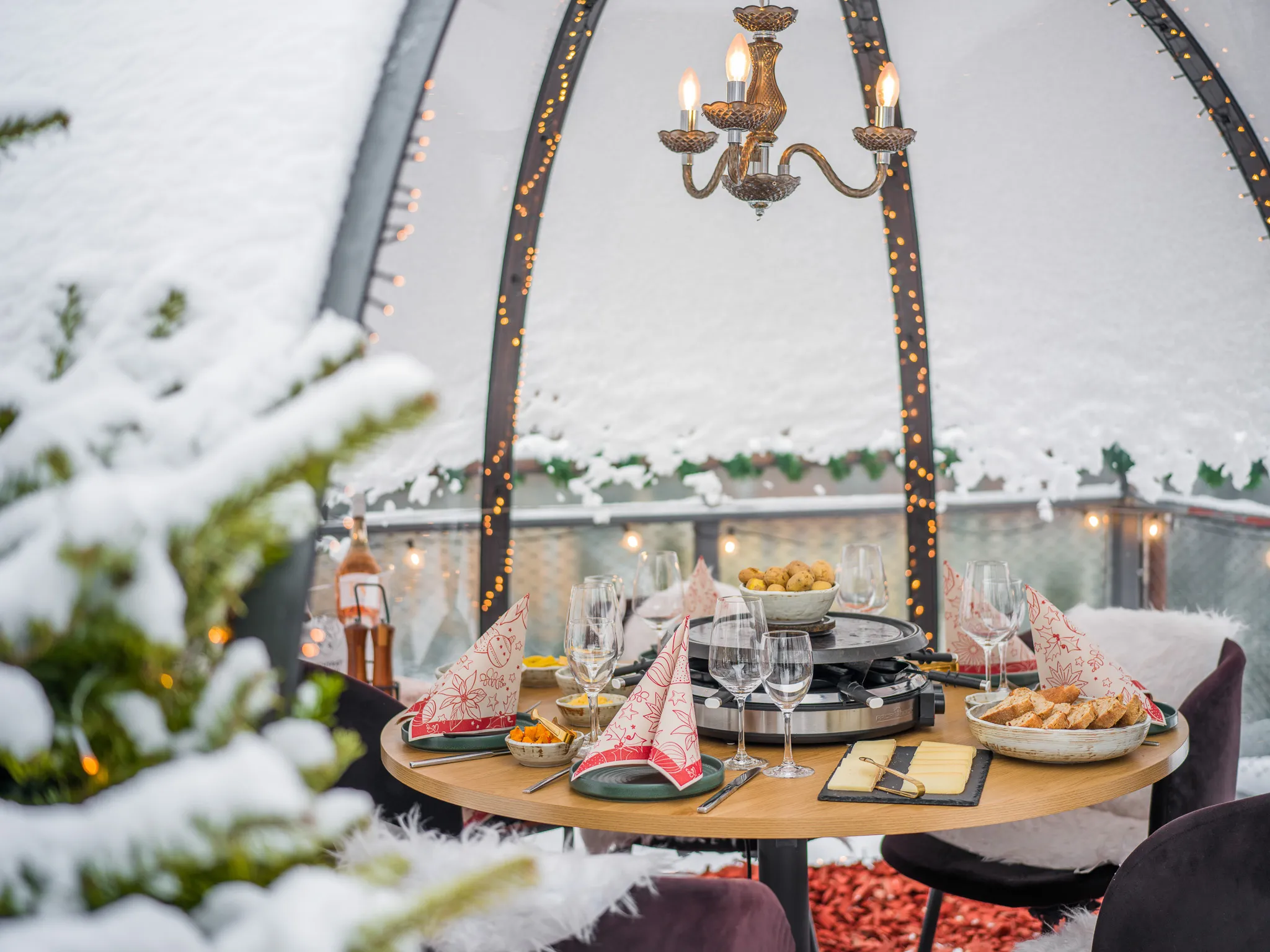 Festlich gedeckter Tisch im Iglu mit Kronleuchter und Schnee